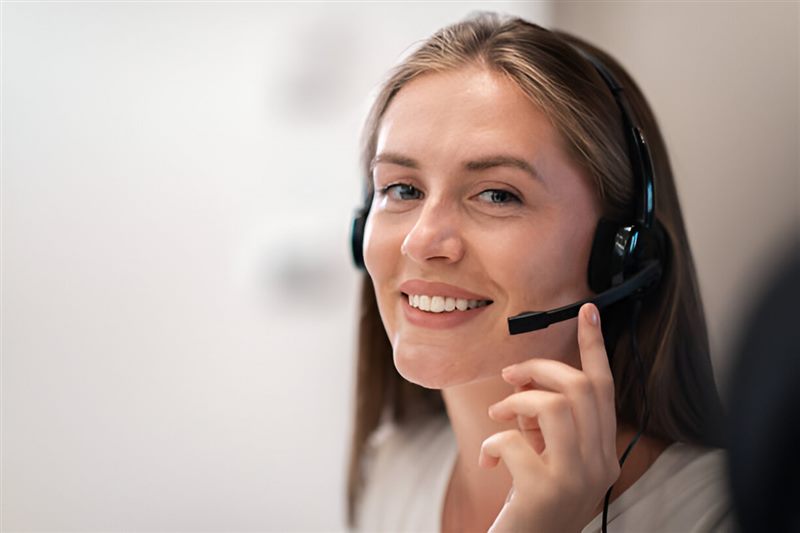 A smiling support adviser wearing a headset