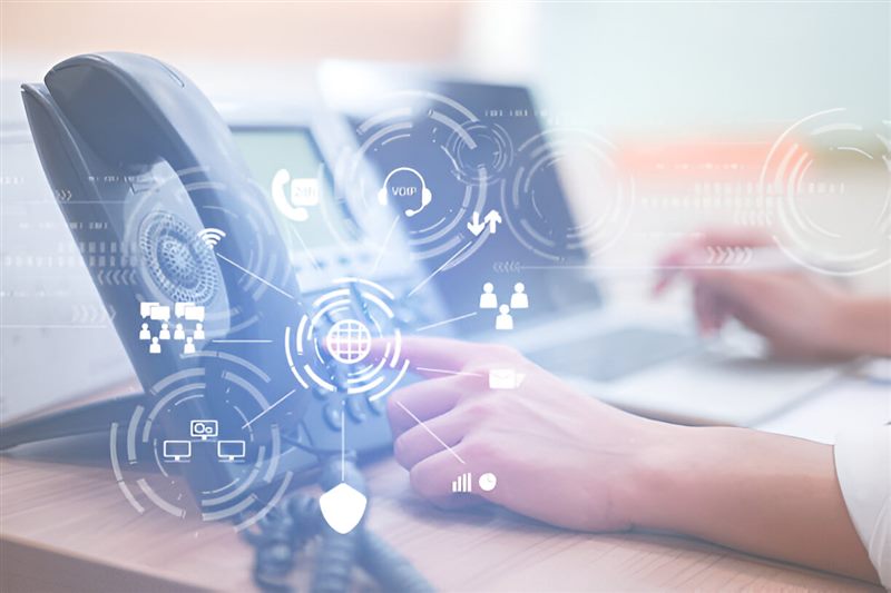 An office phone with digital communication icons over the image
