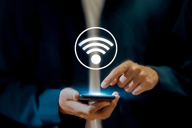 A smartphone under a glowing wi-fi symbol